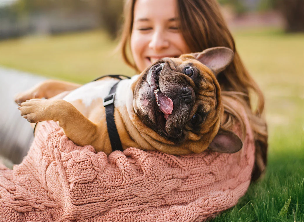 Mujer riendo cargando a su mascota