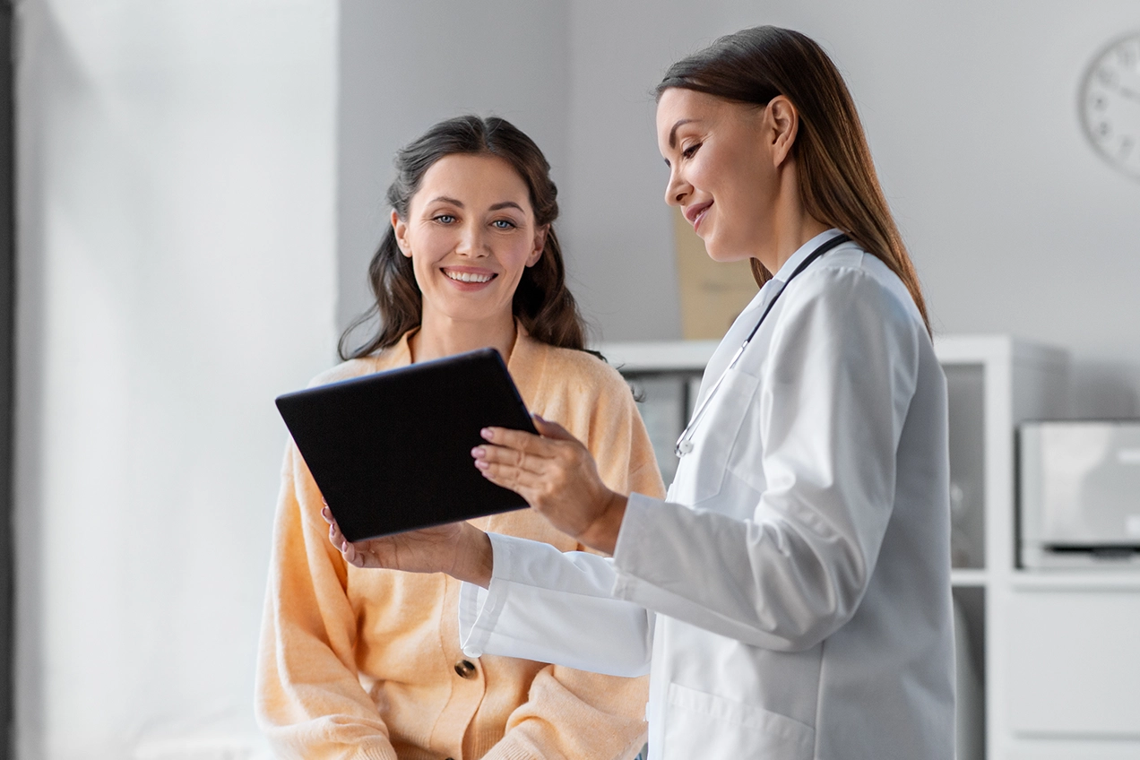 Doctora y paciente mirando una tablet 