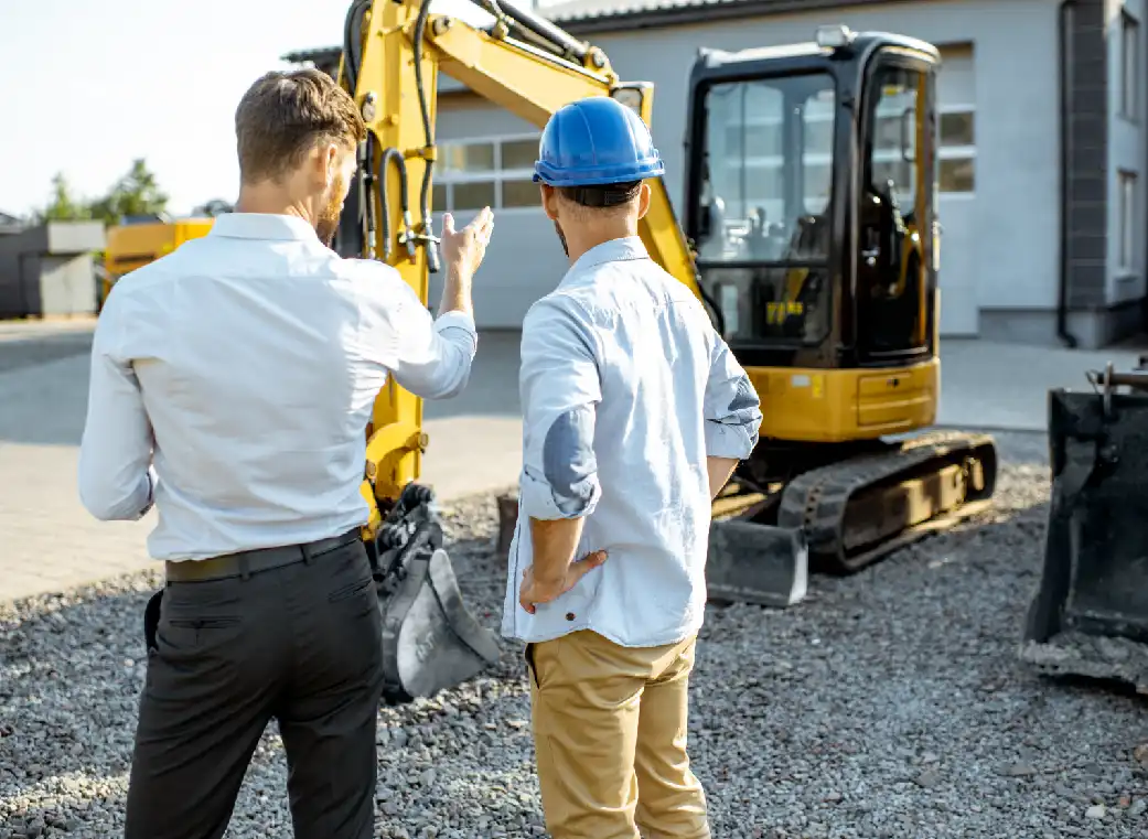 Dos personas observando maquinaria de construcción