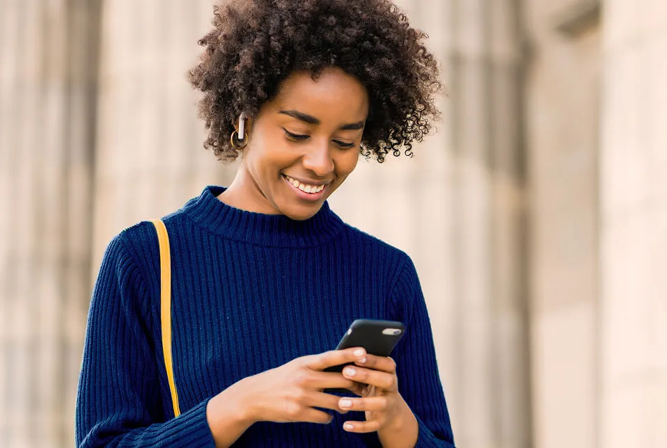 mujer sonriente utilizando teléfono