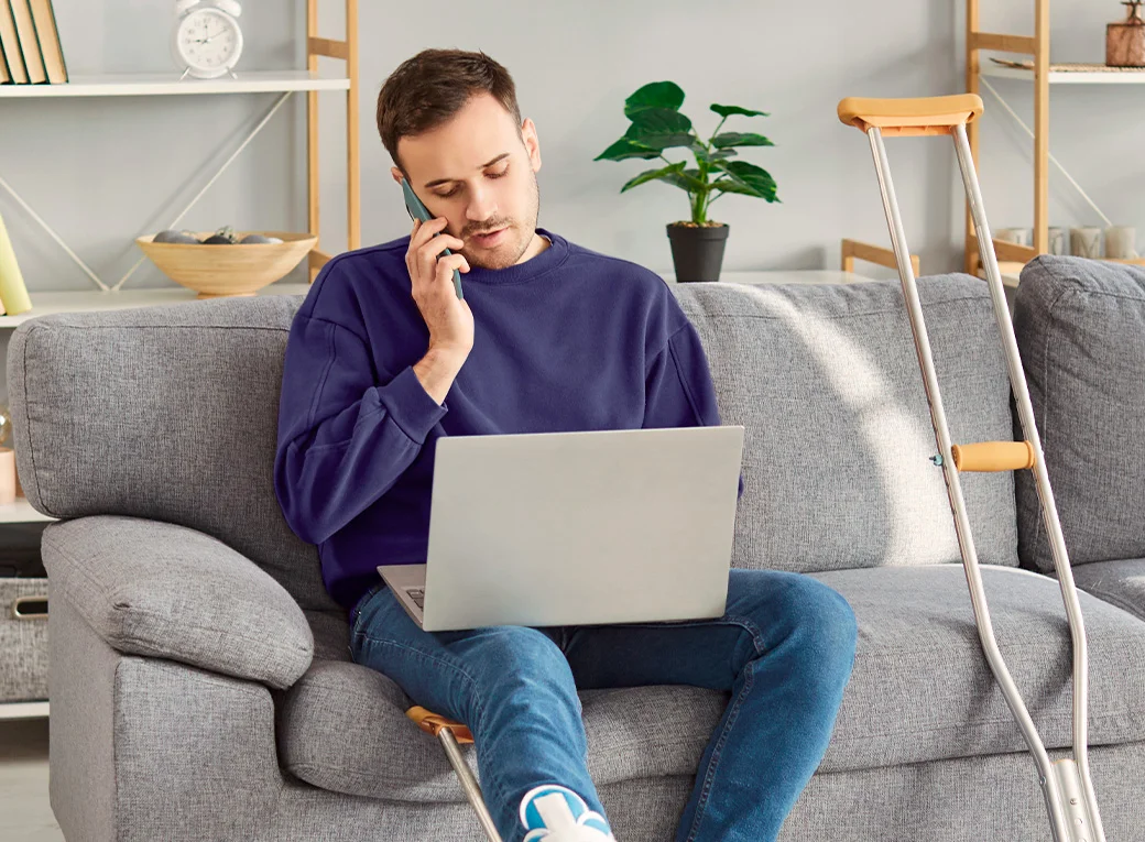 Persona trabajando en una computadora y hablando por teléfono 