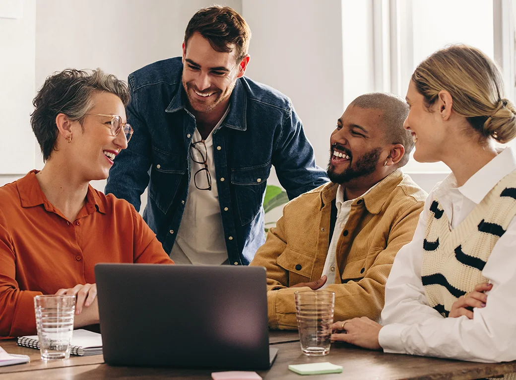 Mesa de trabajo con varias personas sonriendo