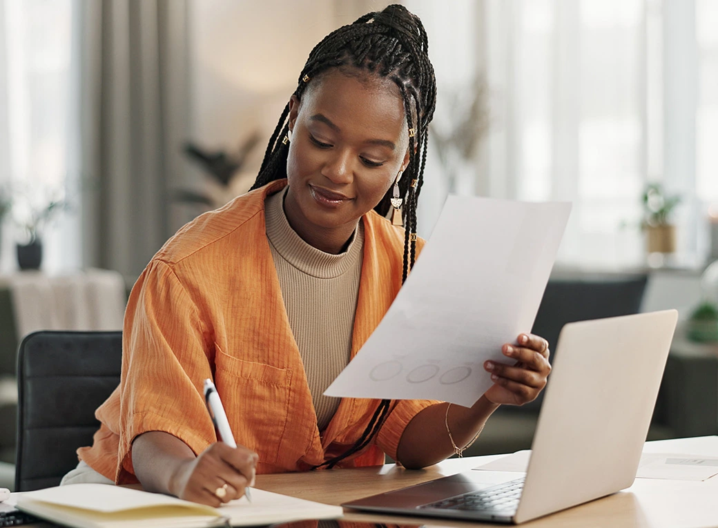 Mujer trabajando coin un compitador, documentos y lapicero